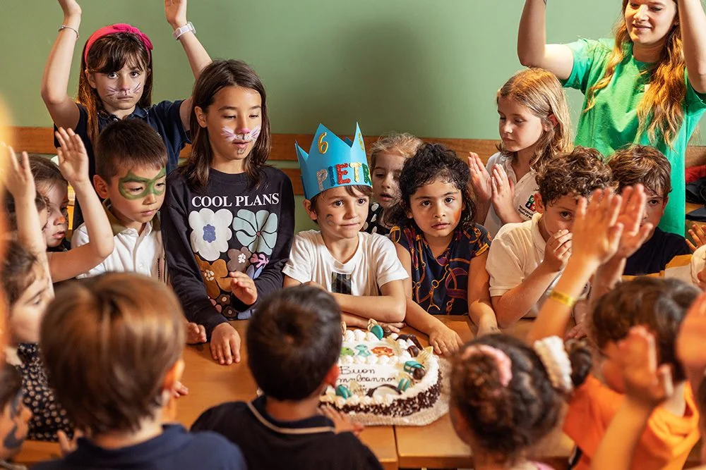 Bambini festeggiano un compleanno intorno alla torta