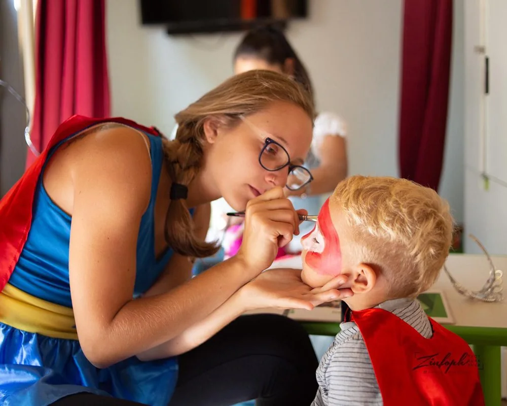 Un’animatrice dipinge il viso di un bambino nell’area kids Benvenuto
