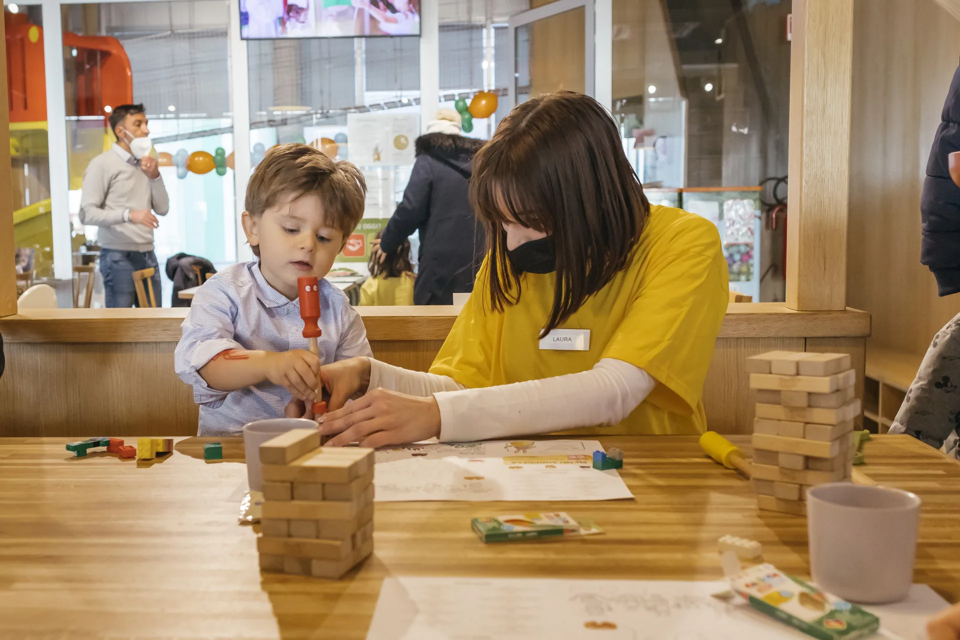 Un bambino e un’animatrice partecipano a un’attività creativa al tavolo