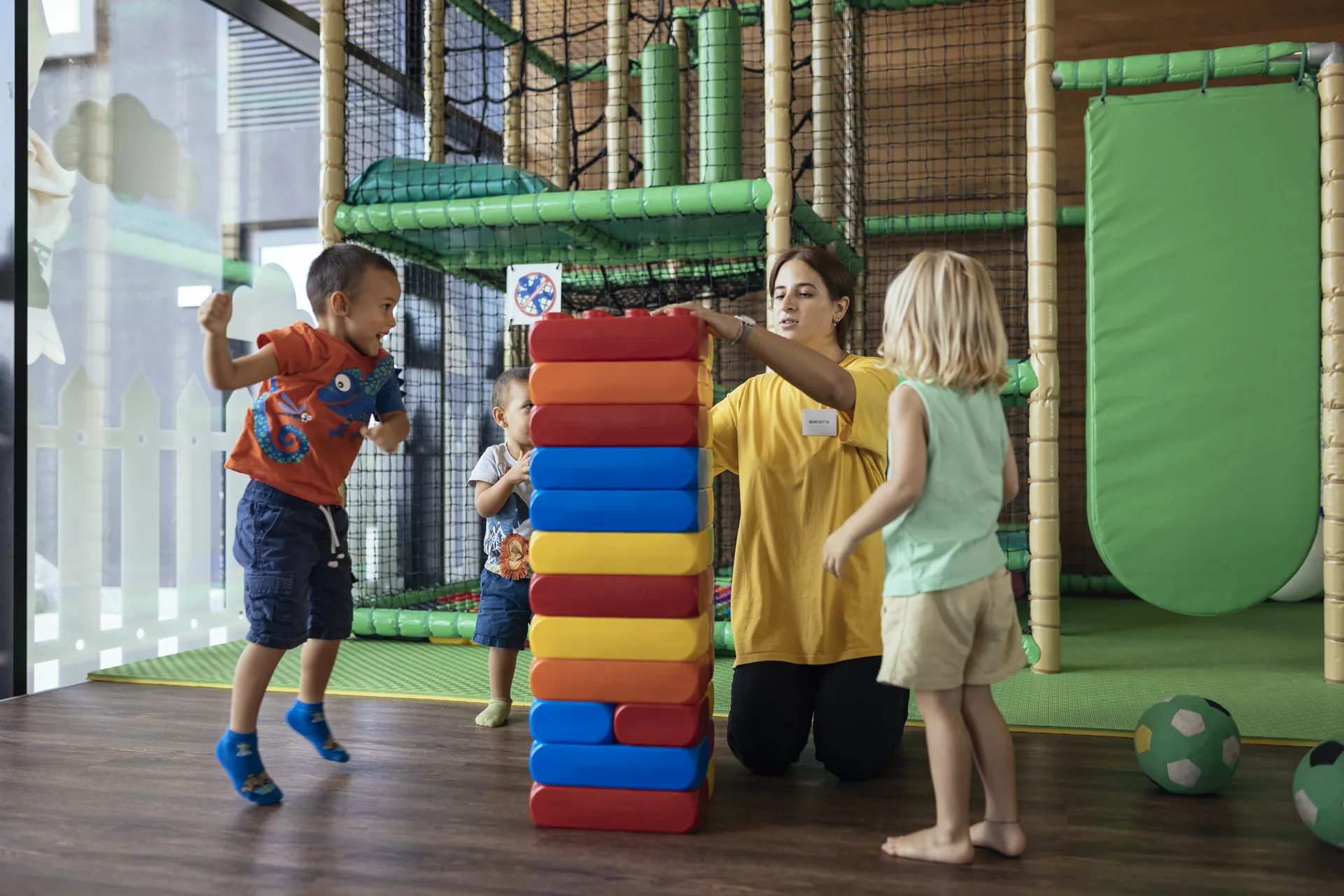 Bambini e un’animatrice giocano con grandi costruzioni colorate nell’area bimbi Benvenuto