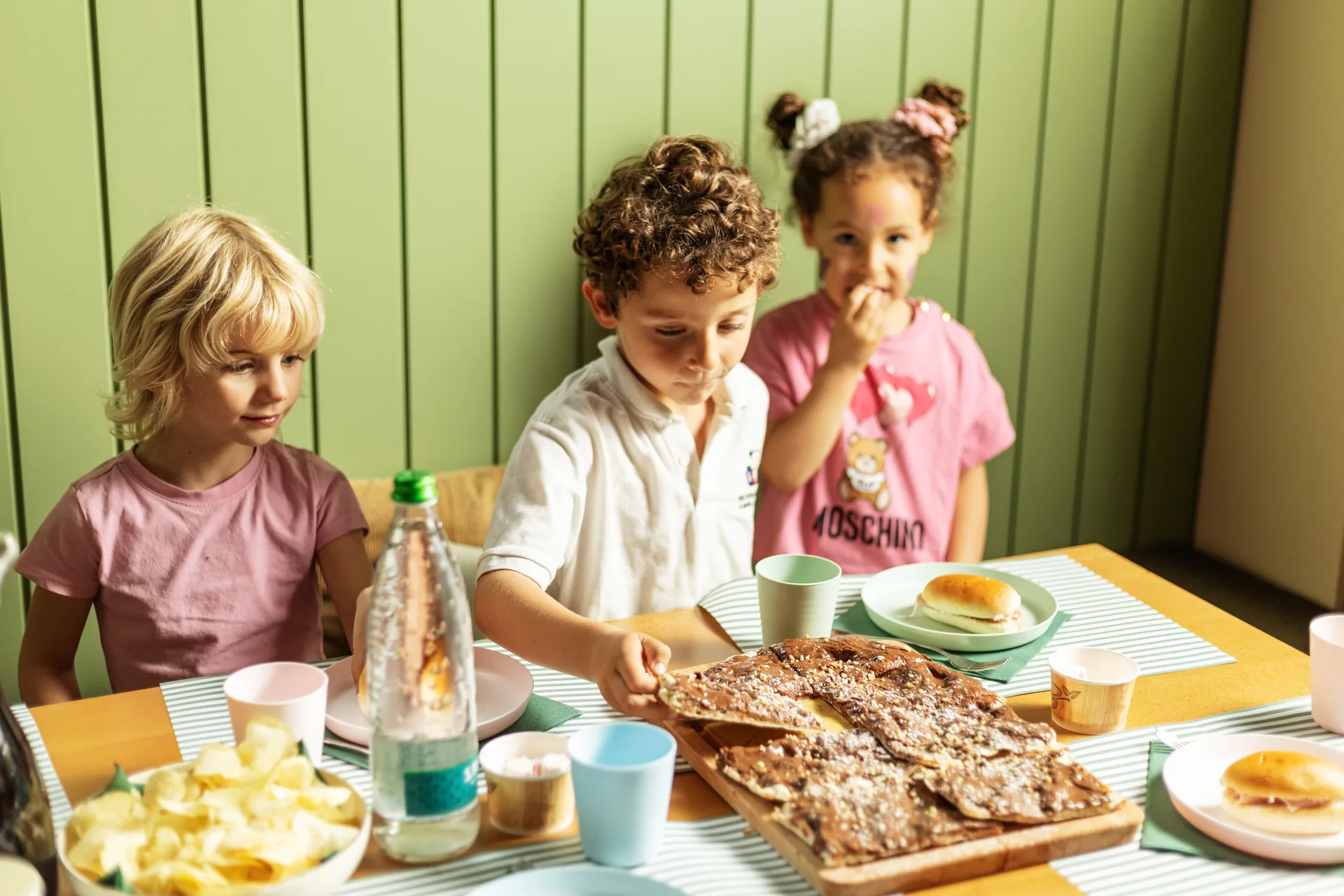 Bambini a merenda con pizza dolce e panini durante una festa Benvenuto