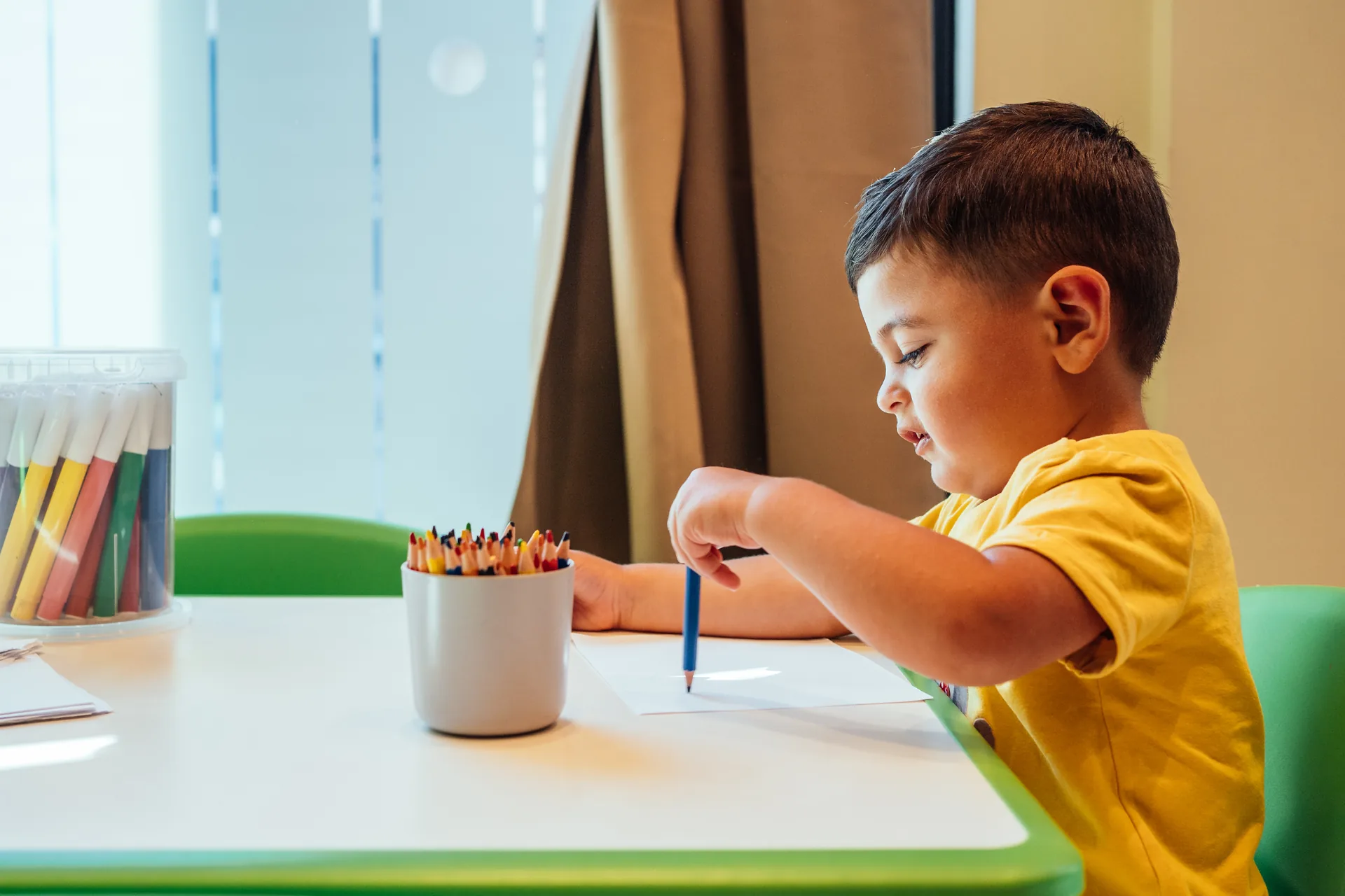 Un bambino disegna con le matite colorate nell’area bimbi Benvenuto